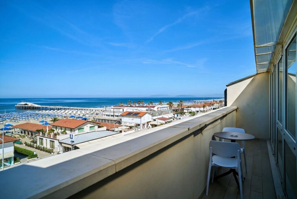 La spiaggia di Lido di Camaiore con gli ombrelloni e il pontile, vista dal balcone all'ultimo piano dell'Hotel La Vela