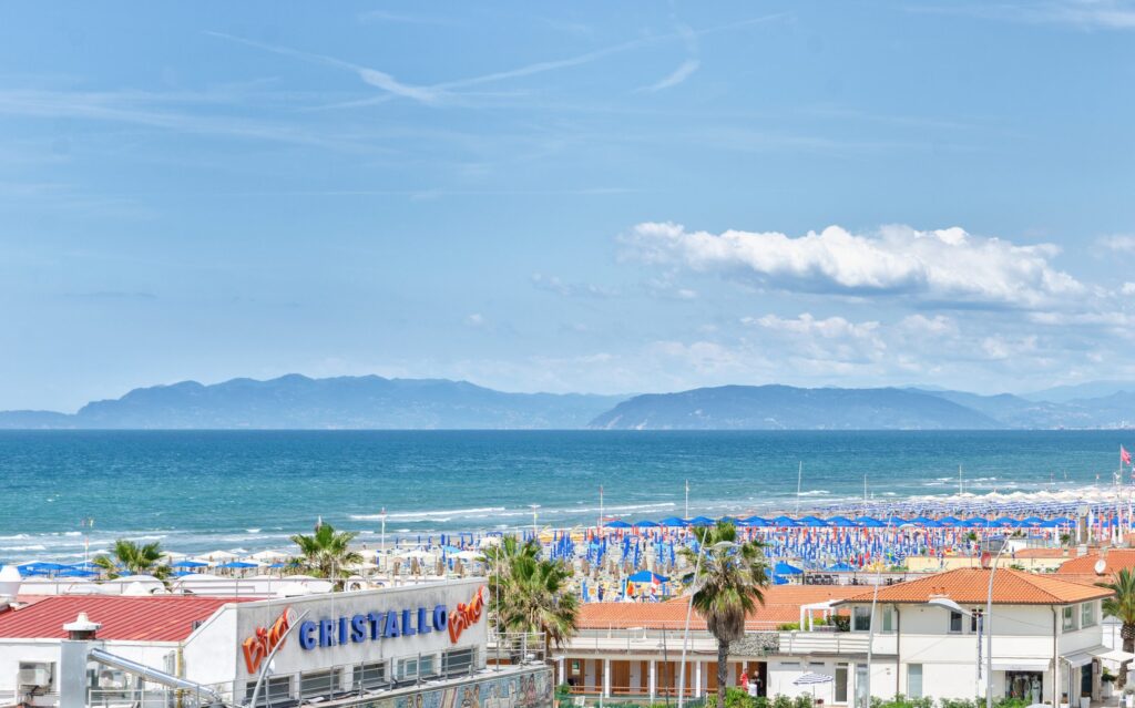 The beach at Lido di Camaiore with the beach club umbrellas and the coast towards Liguria in the background