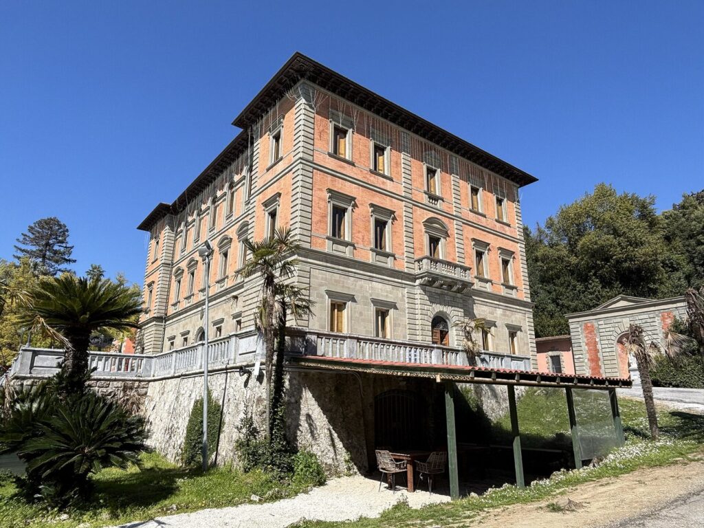 Il palazzo di Villa Borbone delle Pianore a Capezzano Pianore, con il basamento in pietra, la terrazza con la balaustra e le palme